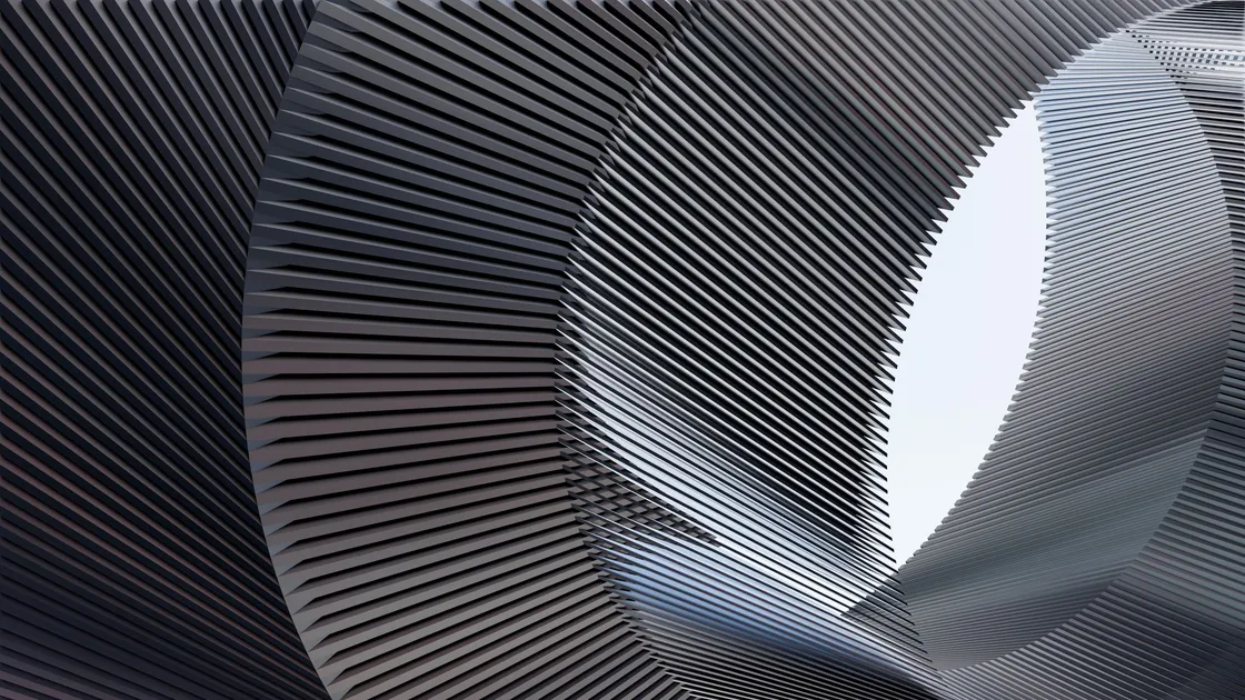 A curved metal structure of closely spaced horizontal fins, lit from behind